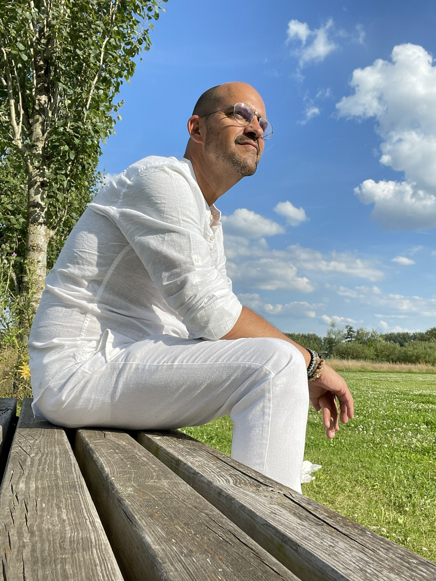 Peter Boaventura Marques in het wit, zittend in de buitenlucht
